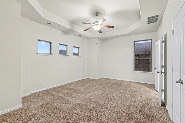 an empty room with fan and windows