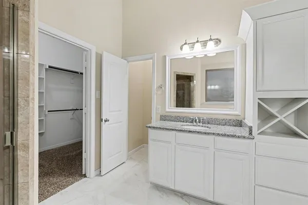a bathroom with a granite countertop sink a mirror and a vanity