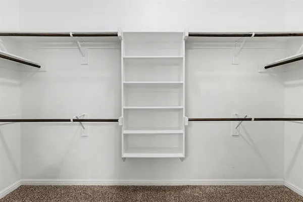 a view of walk in closet with empty racks