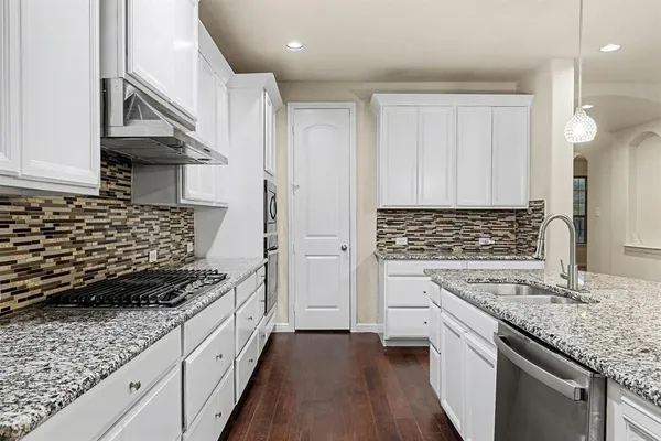 a kitchen with white cabinets and appliances
