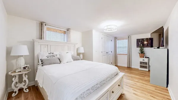 a bedroom with a bed and a flat tv screen on dresser