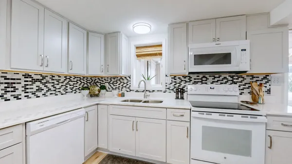 a kitchen with white cabinets sink and white appliances