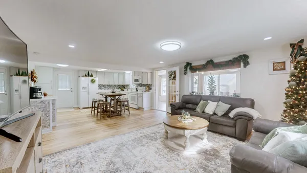 a living room with furniture and a dining table with kitchen view