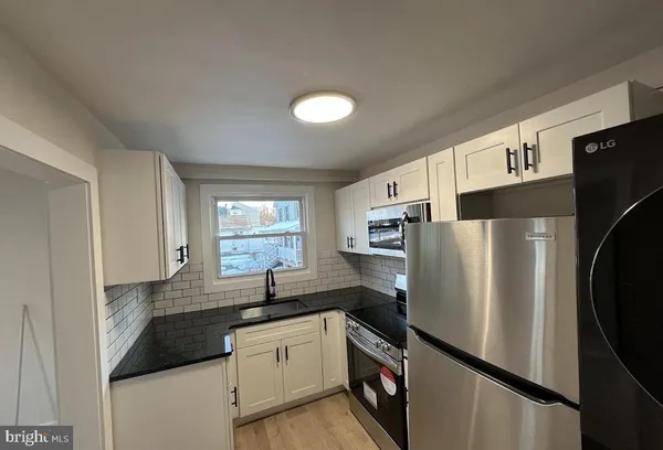 a kitchen with granite countertop a refrigerator and a sink