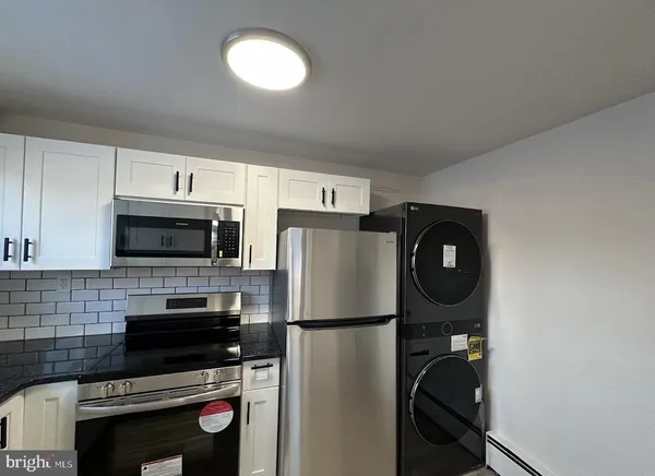 a kitchen with a refrigerator a stove and cabinets