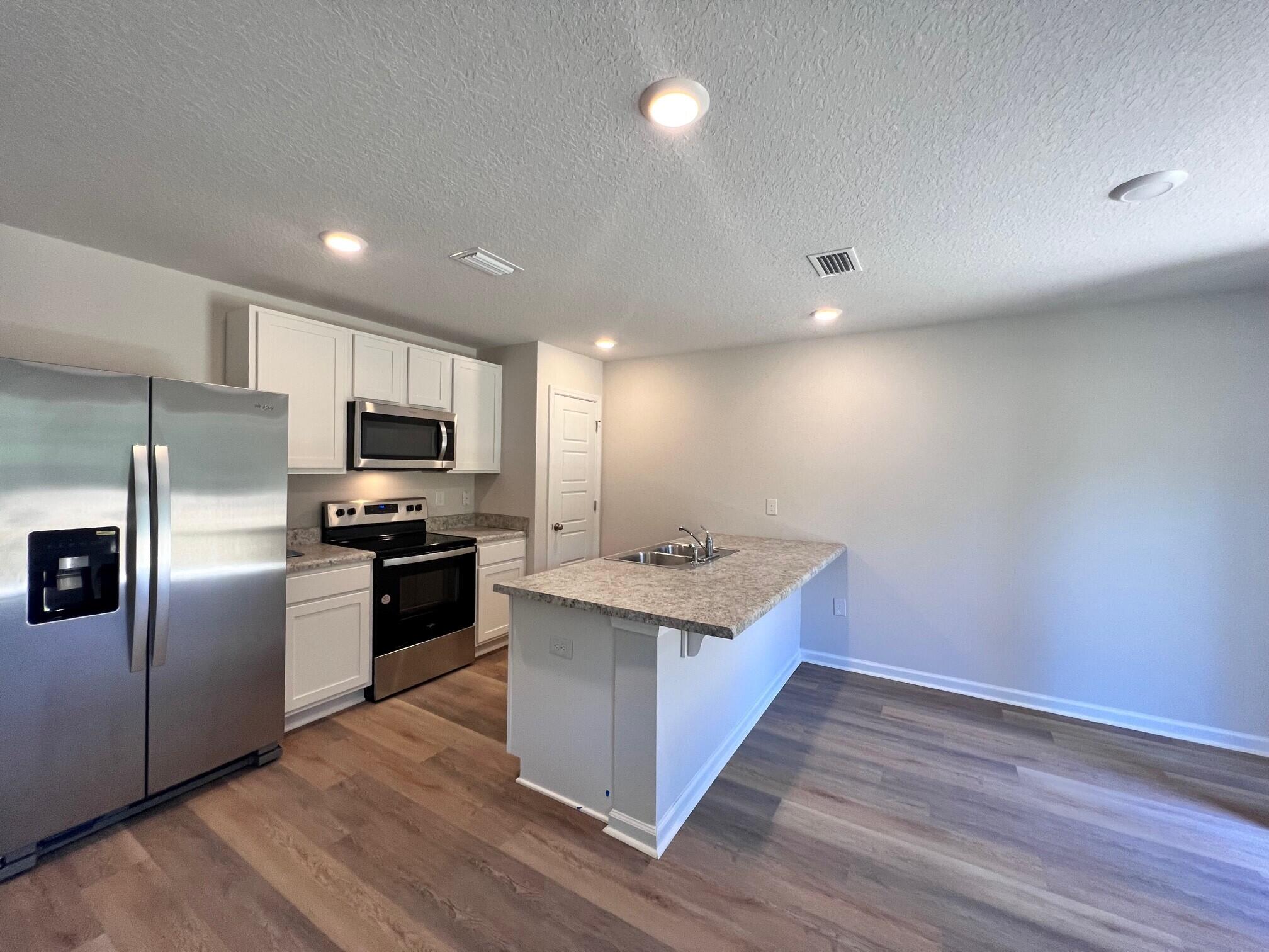 3125 Van Day Way Crestview, FL 32539 - Photo 3 of 24 a kitchen with stainless steel appliances a sink stove and refrigerator