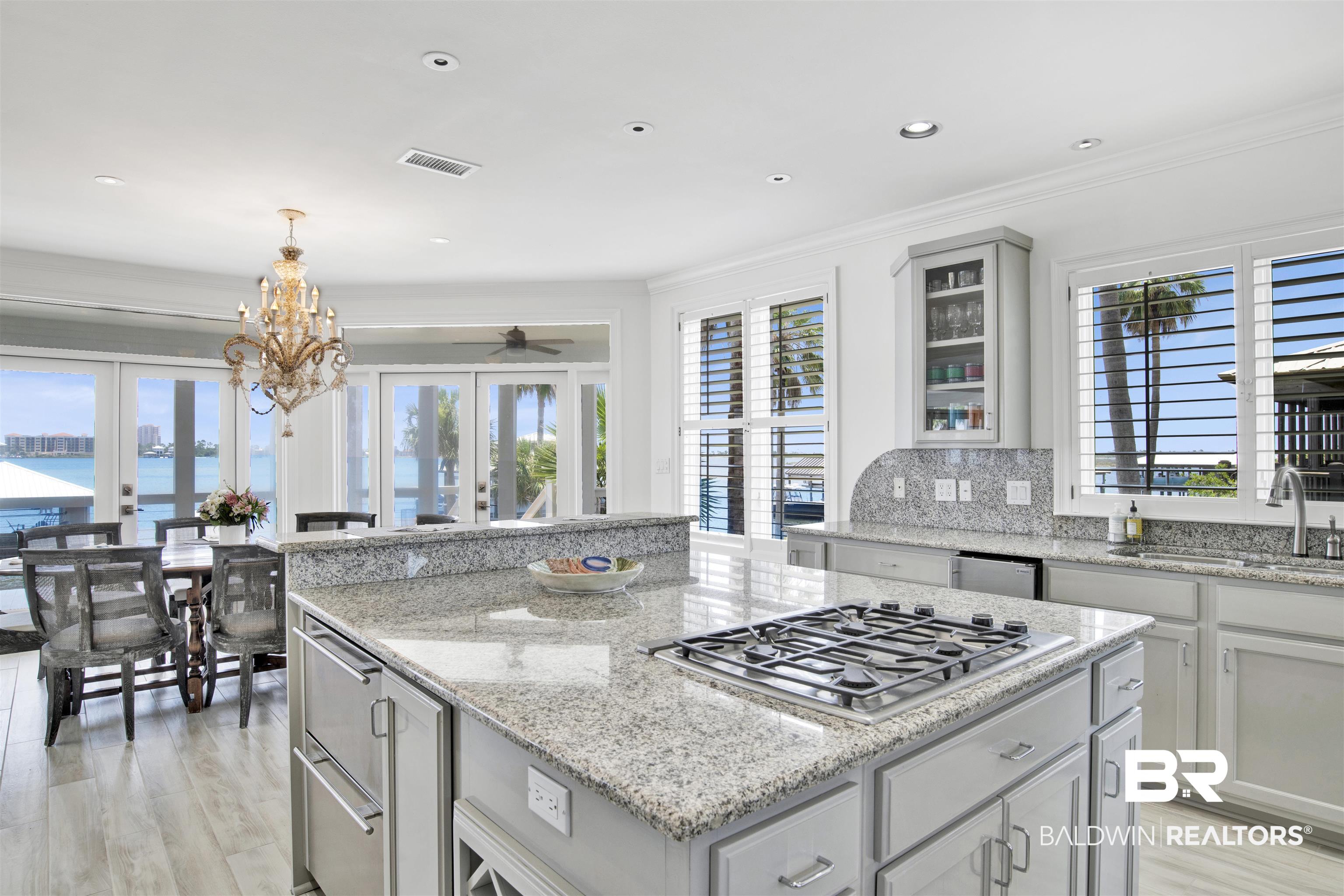 33400 River Road Orange Beach, AL 36561 - Photo 33 of 72 Kitchen featuring appliances with stainless steel finishes, light hardwood / wood-style flooring, french doors, hanging light fixtures, and decorative backsplash