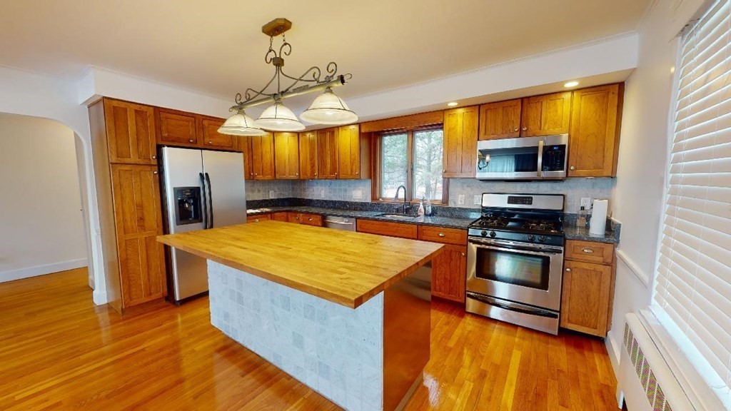a kitchen with stainless steel appliances wooden floor sink and microwave