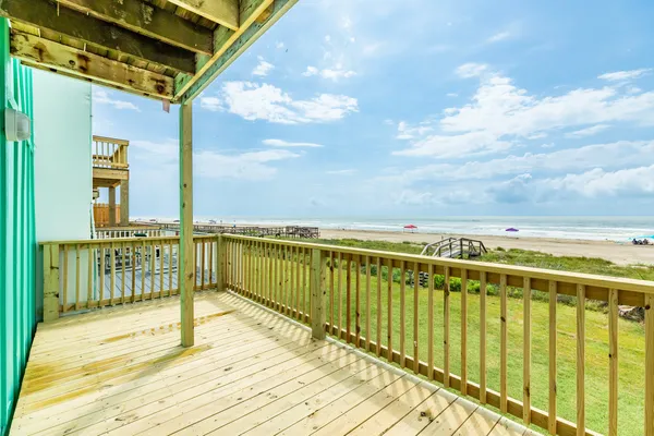 a view of balcony with wooden floor & fence