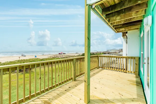a view of a balcony with wooden floor and fence