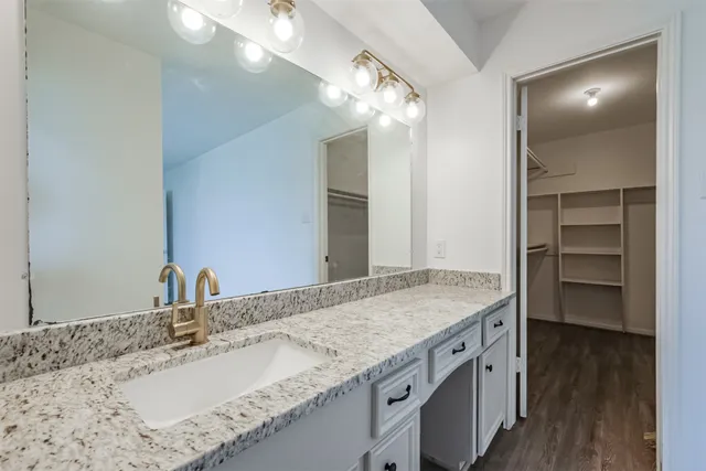 a bathroom with a granite countertop sink and a mirror