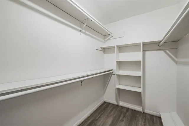a view of walk in closet with empty racks