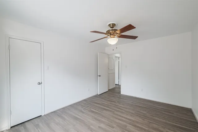 a view of a big room with wooden floor and a ceiling fan