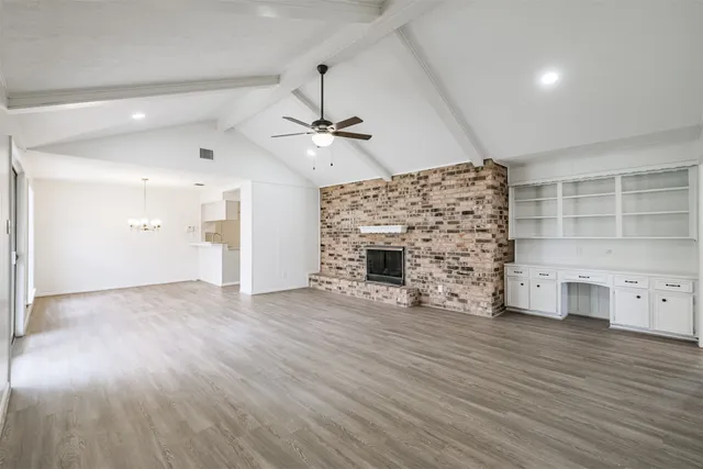 a view of empty room with a fireplace and wooden floor
