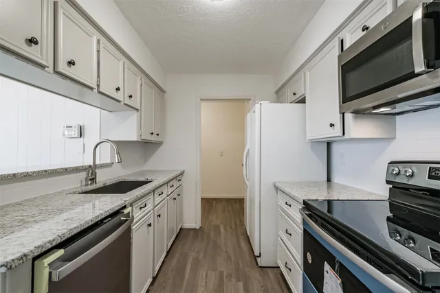 a kitchen with stainless steel appliances granite countertop a sink stove and microwave