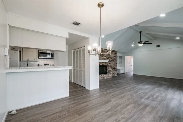 a view of a kitchen with a sink refrigerator and wooden floor