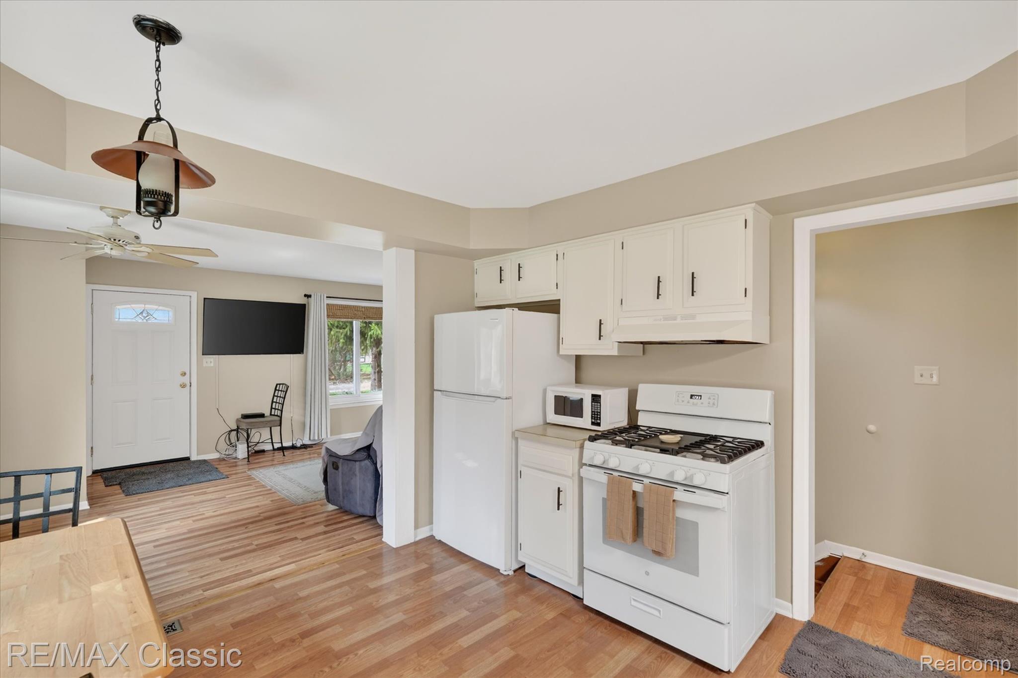 5060 Warmbriar Road White Lake, MI 48383 - Photo 18 of 34 Kitchen with white appliances, light countertops, a ceiling fan, light wood-style flooring, and white cabinetry