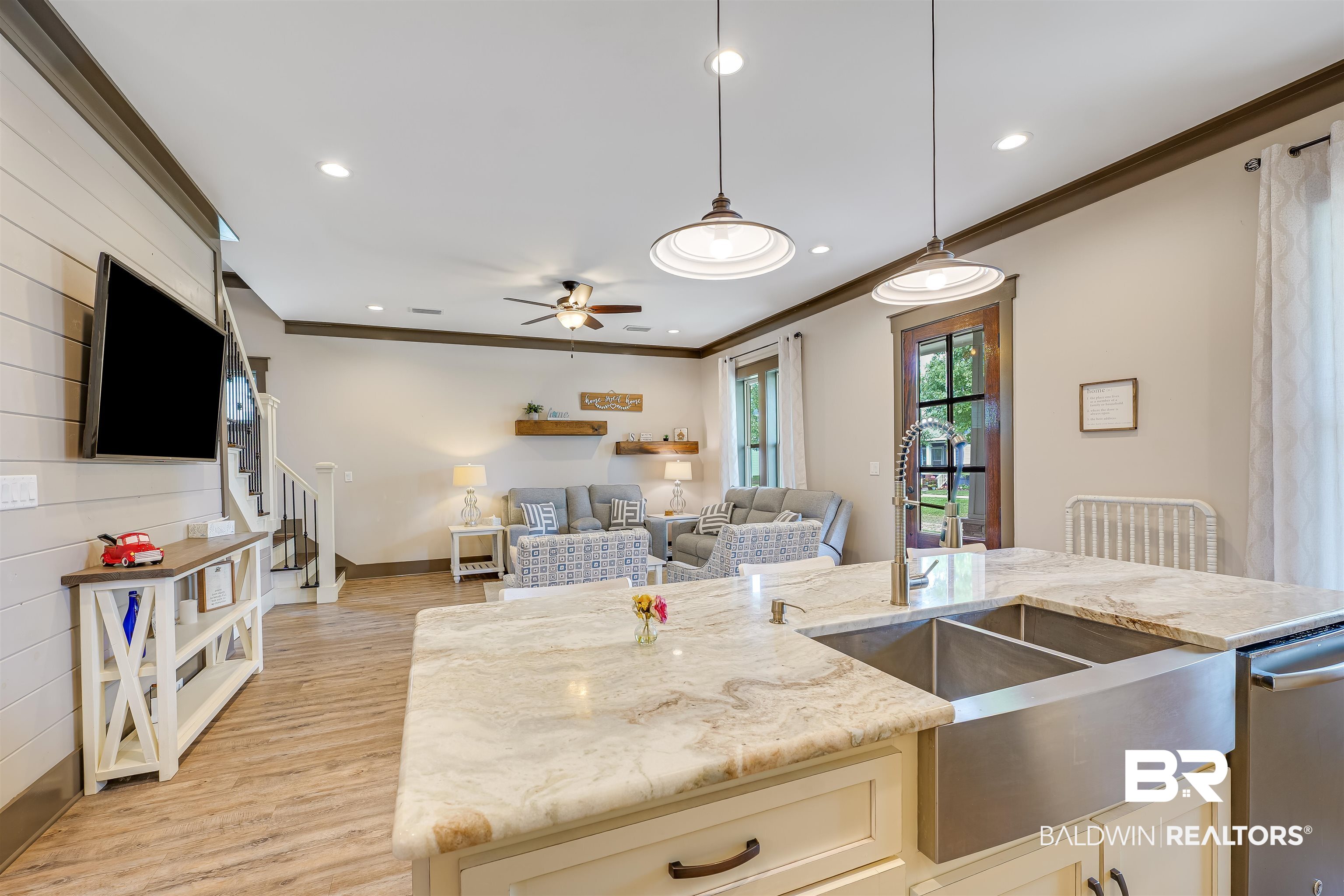 1119 Pink Poppy Lane Foley, AL 36535 - Photo 22 of 38 Kitchen featuring crown molding, light stone counters, light wood finished floors, decorative light fixtures, and stainless steel dishwasher