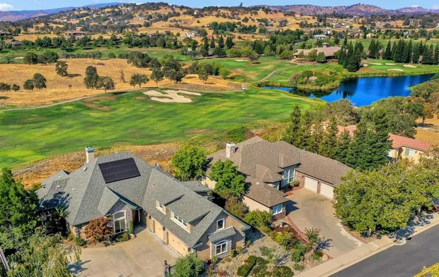 an aerial view of a house with a garden and lake view
