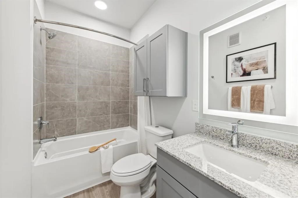 10350 Blue Bluff Road, Unit 6107 Austin, TX 78724 - Photo 10 of 27 a bathroom with a granite countertop sink a toilet and shower