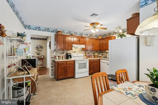 a kitchen with stainless steel appliances granite countertop a stove top oven a sink a dining table and chairs