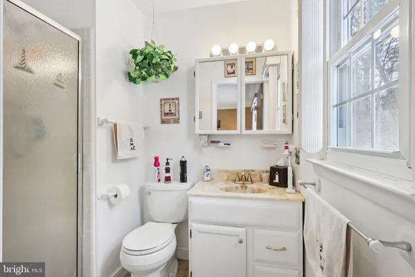 a bathroom with a granite countertop toilet sink and mirror