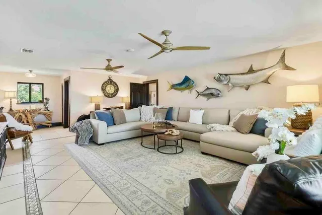 a living room with furniture a rug and a ceiling fan