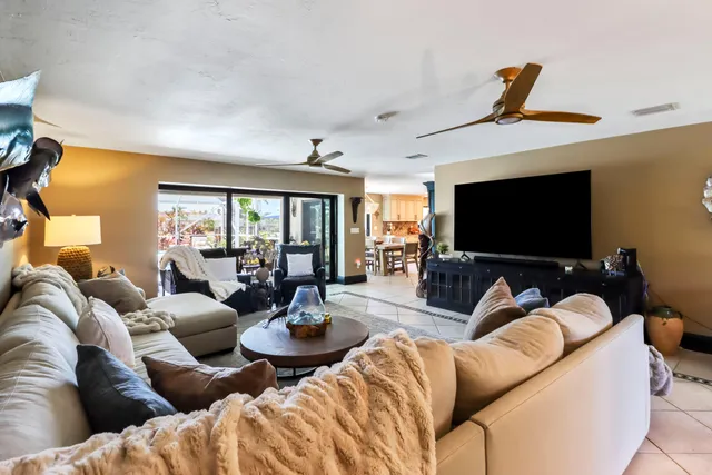 a kitchen with kitchen island granite countertop a table chairs sink and cabinets