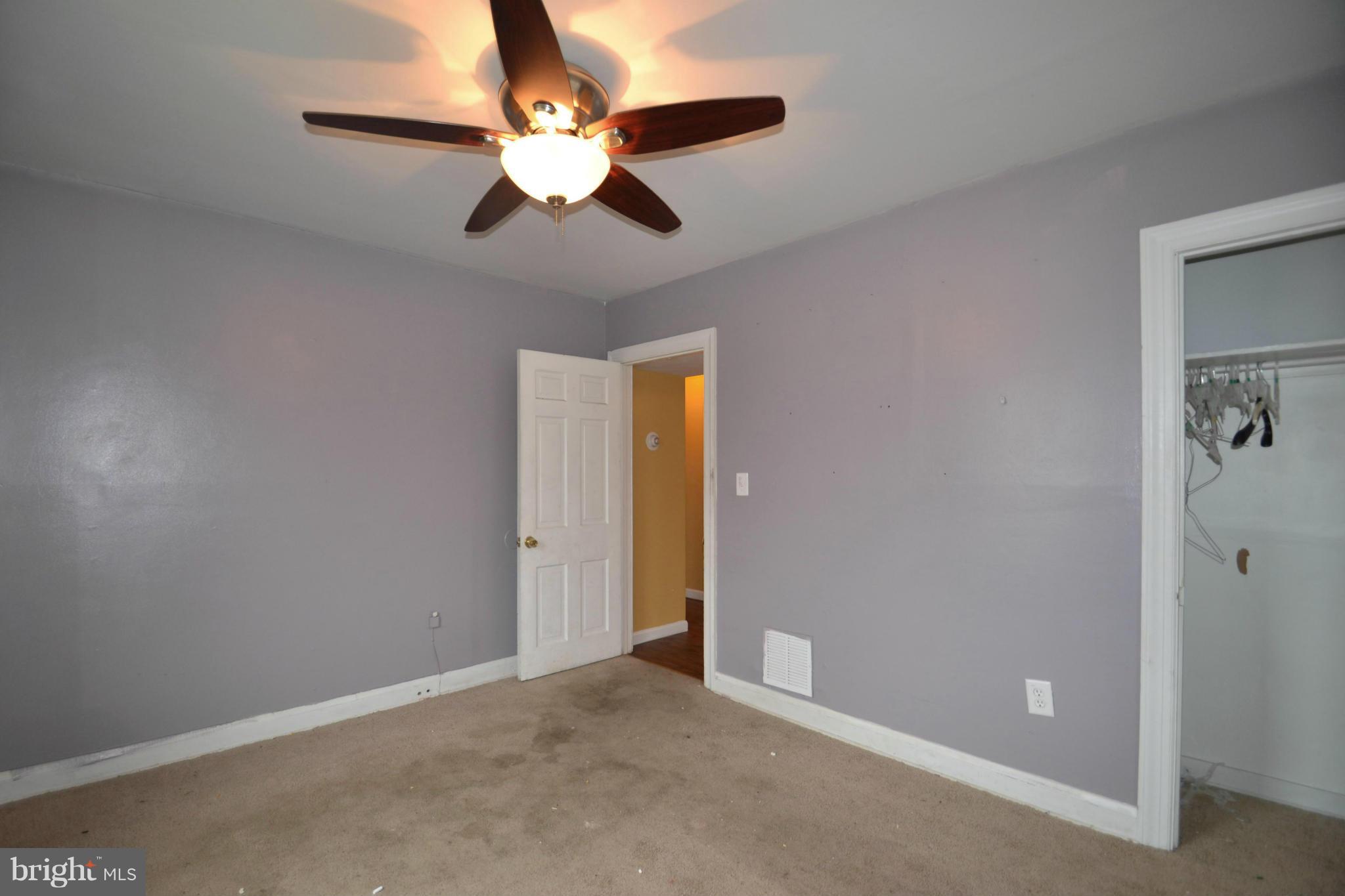 3211 Rosalie Road Baltimore, MD 21227 - Photo 13 of 25 an empty room with a chandelier fan and windows