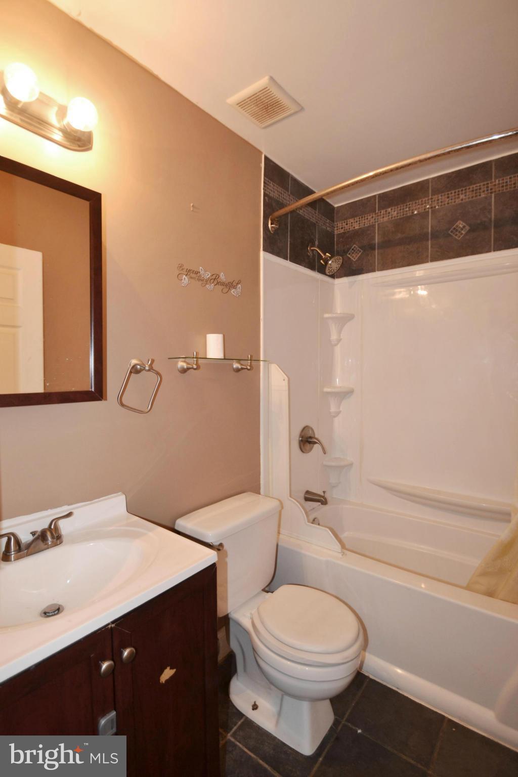 3211 Rosalie Road Baltimore, MD 21227 - Photo 14 of 25 a bathroom with a sink a toilet a mirror and shower