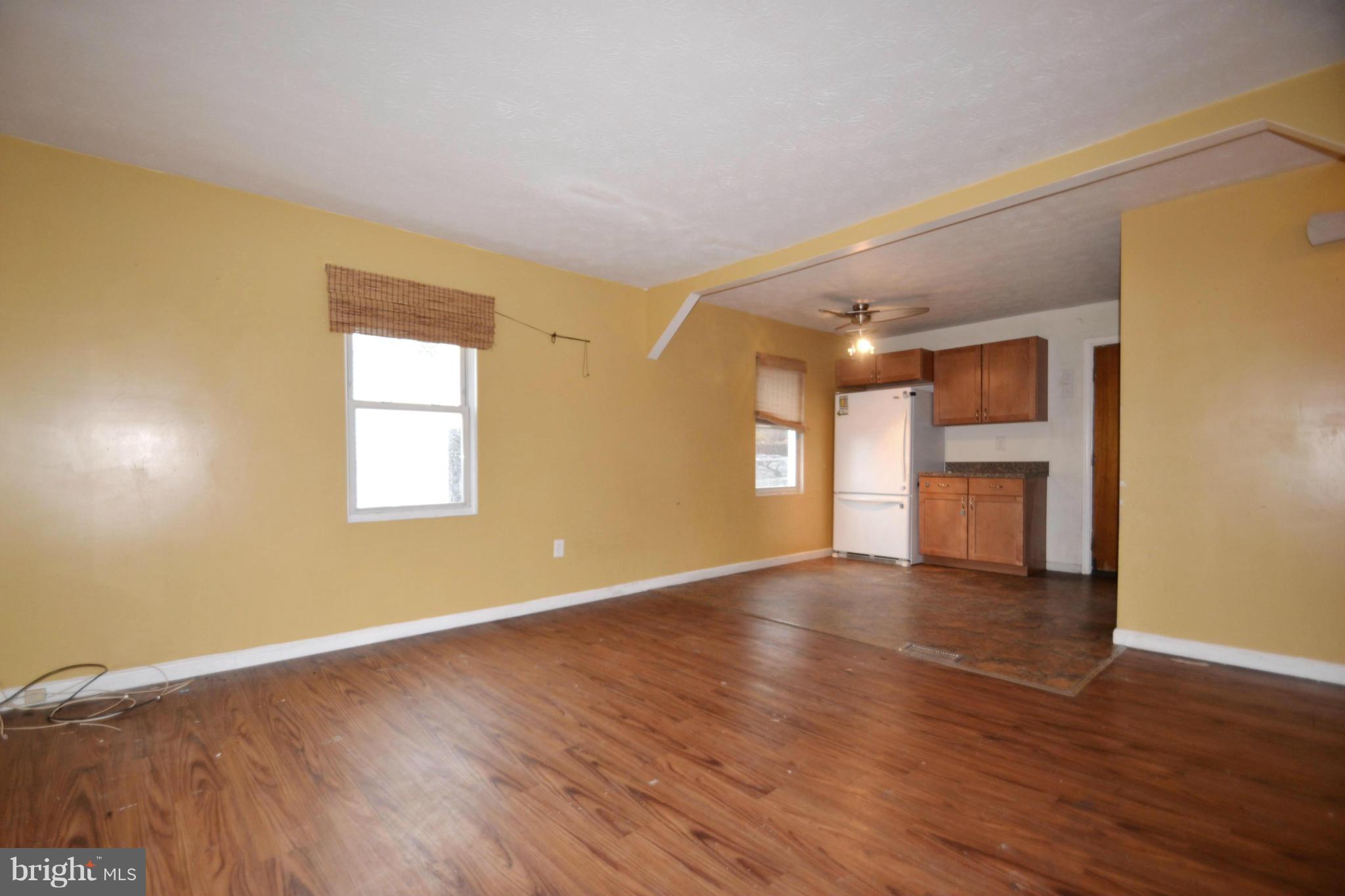 3211 Rosalie Road Baltimore, MD 21227 - Photo 4 of 25 a view of an empty room with wooden floor and a window