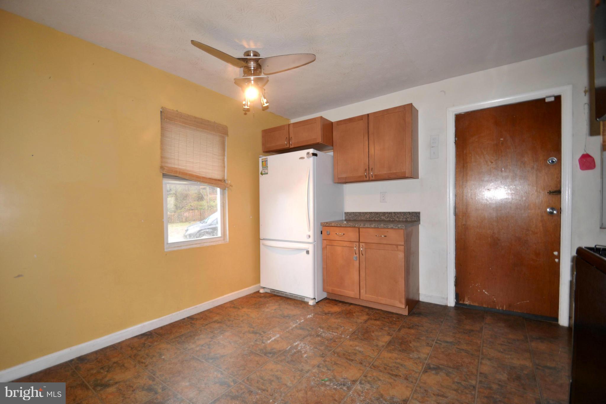 3211 Rosalie Road Baltimore, MD 21227 - Photo 6 of 25 a view of a kitchen with a sink and a refrigerator