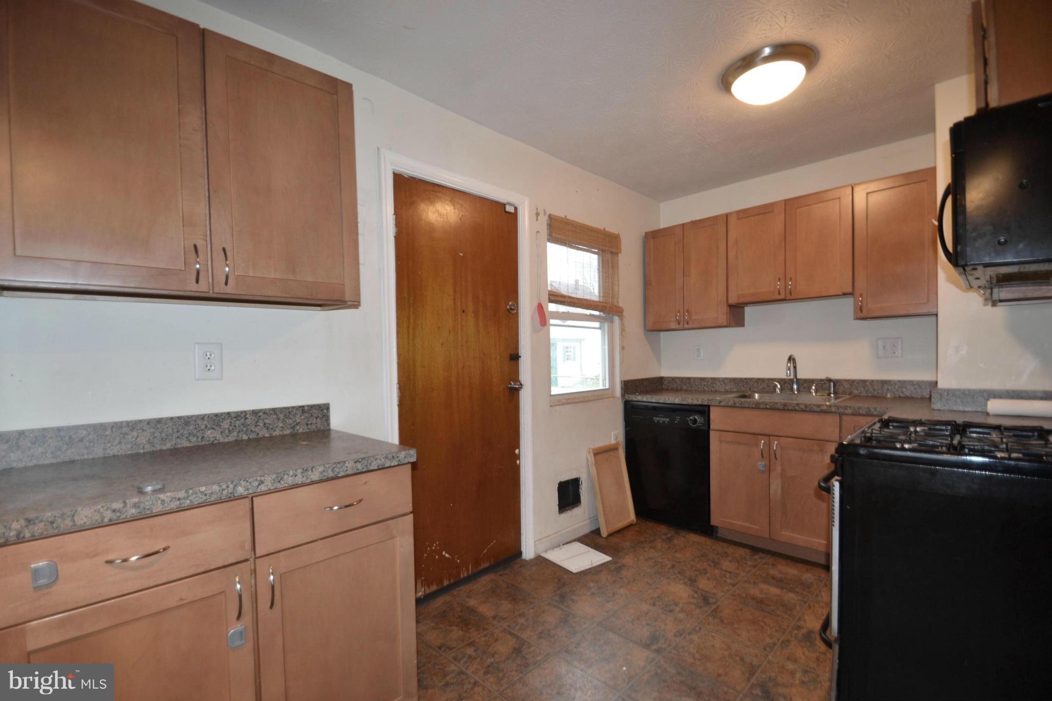 3211 Rosalie Road Baltimore, MD 21227 - Photo 7 of 25 a kitchen with granite countertop a sink stove and refrigerator