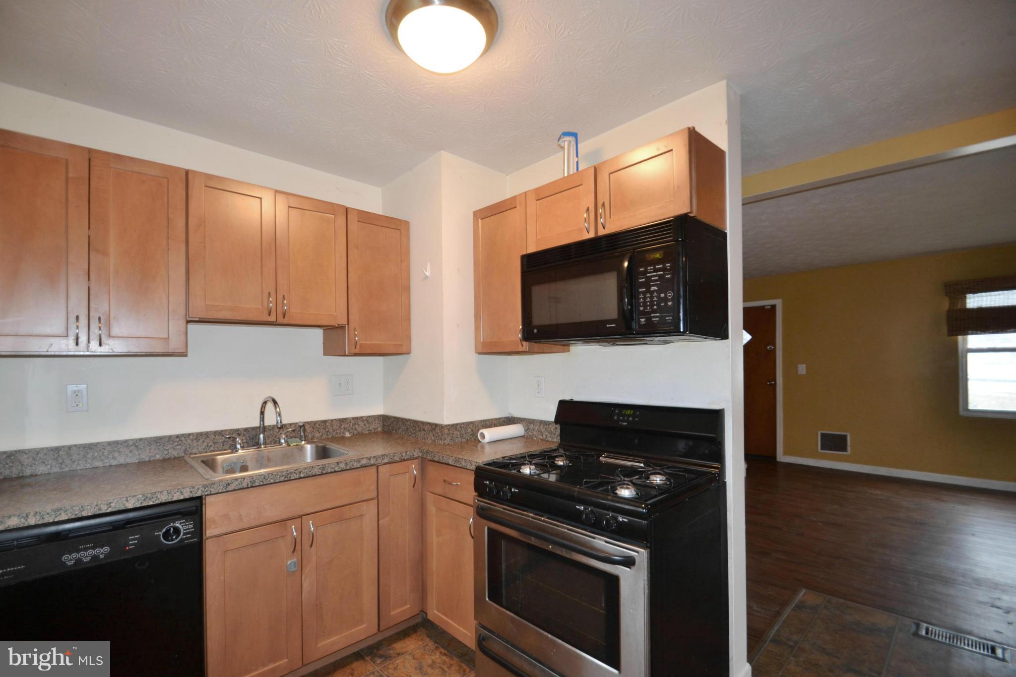 3211 Rosalie Road Baltimore, MD 21227 - Photo 10 of 25 a kitchen with a sink stove and microwave