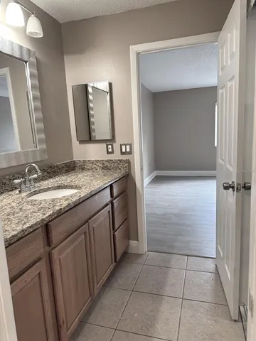 a bathroom with a granite countertop sink a mirror and a vanity