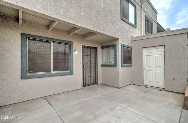 an empty room with wooden floor ceiling fan and windows