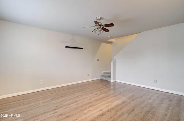 a view of empty room with wooden floor and window