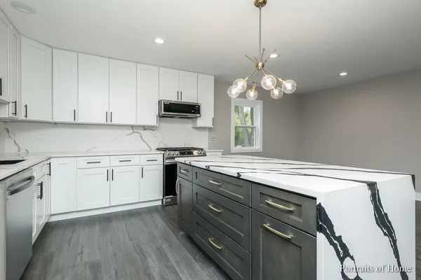 a kitchen with a stove a sink and a chandelier