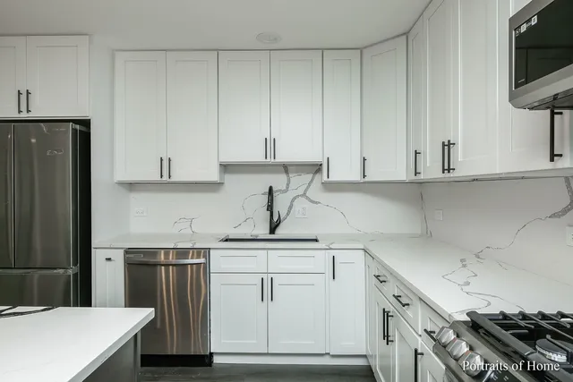 a kitchen with white cabinets and appliances