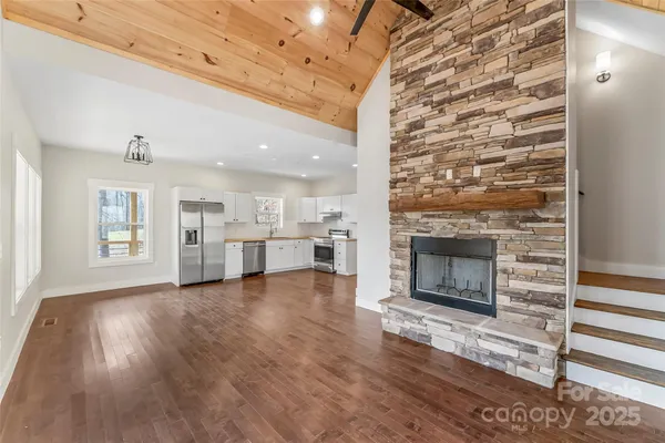a view of a livingroom with wooden floor and a fireplace