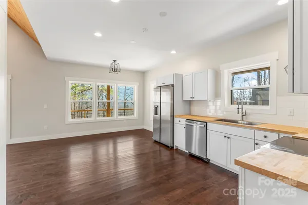 a large kitchen with stainless steel appliances granite countertop a sink and wooden floor