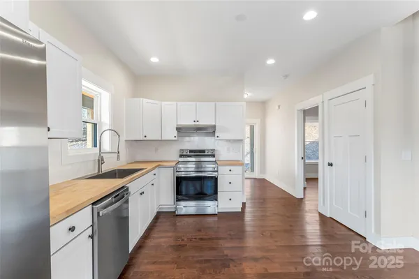 a large kitchen with stainless steel appliances granite countertop a sink and cabinets