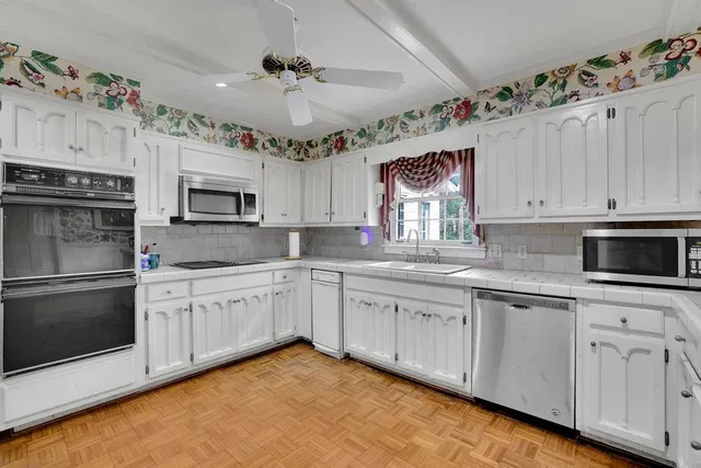 a kitchen with stainless steel appliances kitchen island granite countertop a refrigerator and a stove top oven