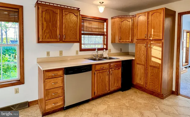 a kitchen with a sink cabinets appliances and a window