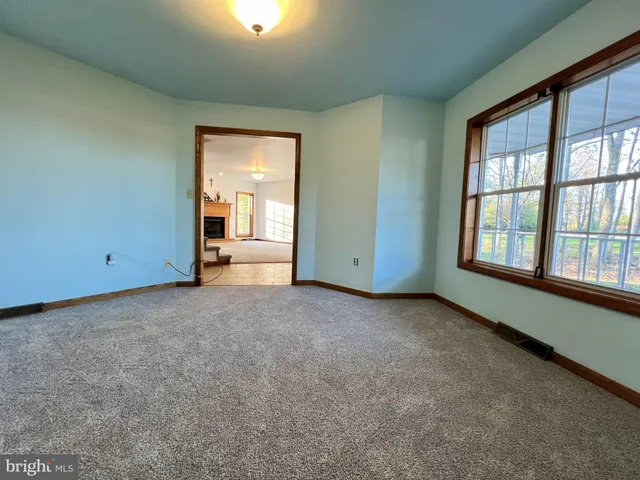 an empty room with a fireplace and large windows