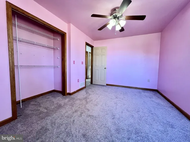 a view of a room with a ceiling fan and a window