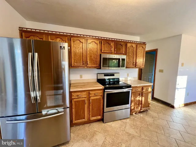a kitchen with stainless steel appliances granite countertop a refrigerator stove and microwave