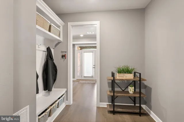 a view of a hallway with wooden floor and a potted plant