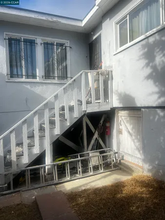a view of a house with backyard and sitting area