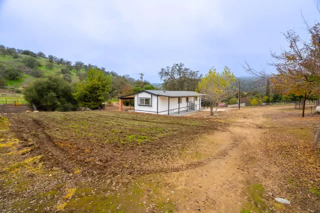 a view of a house with a yard and sitting area